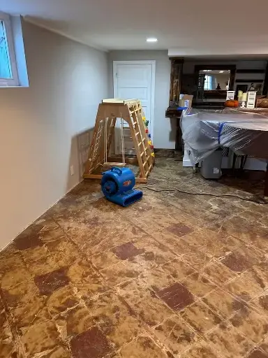 Air mover drying an exposed floor in a family room in Garden Grove