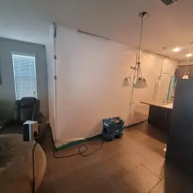 Plastic containment wall and an air scrubber set up beside a kitchen in Garden Grove