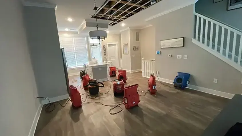 Air movers and a dehumidifier set across a wet living room floor in Garden Grove